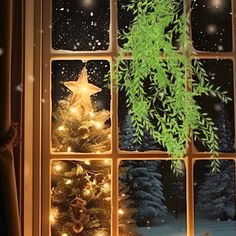 a christmas tree is lit up in front of a window with snow falling on it