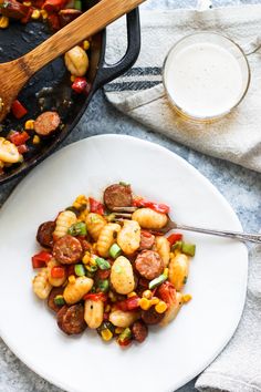 a white plate topped with shrimp and veggies next to a glass of milk