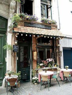 an old building with tables and chairs outside