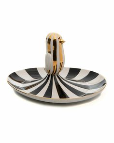 a black and white striped plate with a bird on the top, sitting on it's side