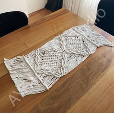 a table that has some kind of woven object on it's side, sitting on top of a wooden table