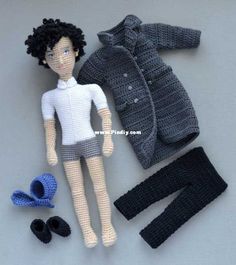 a crocheted doll with clothes and shoes on a gray surface, next to it's contents