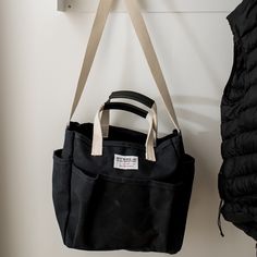 a black bag hanging on the wall next to a coat rack