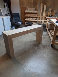 a wooden bench sitting on top of a hard wood floor next to a white refrigerator