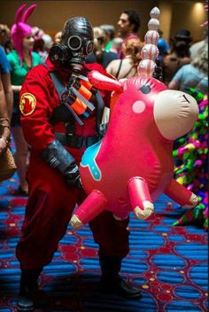 a man in a gas mask and red jumpsuit is holding a balloon shaped like a cat