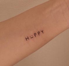 a woman's arm with the word happy written in small black letters on it