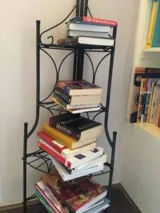 a stack of books sitting on top of a metal shelf