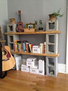 a guitar and bookshelf in the corner of a room