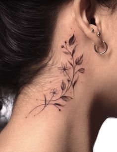 a woman's behind the ear tattoo with flowers