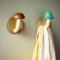 two mushrooms are mounted on the wall next to towels