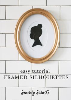 the silhouette of a woman's head in a gold frame on a white tiled wall