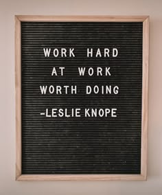 a sign that says work hard at work worth doing lesie knope on it