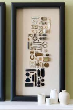 a shadow box frame with assorted items in it on a shelf next to two vases