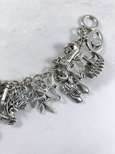 This fun charm bracelet is the perfect accessory to showcase your love for the Greek myths. Charms included: Lightning bolt for Zeus Sea horse for Poseidon Skull for Hades Axe for Hephaestus Wine goblet for Dionysus Lyre for Apollo Bow & Arrow for Artemis Owl for Athena Heart for Aphrodite Caduceus for Hermes Boar for Ares Fire for Hestia Peacock for Hera Wheat for Demeter Pomegranate for Persephone Key for Hekate Medusa head Cupid cherub for Eros Sun for Helios Moon for Selene Music Note fo Spiritual Charm Bracelet With Dangling Charms, Cupid Cherub, Greek Mythology Jewelry, Mythology Jewelry, God Goddess, Bow Arrow, Diy Jewlery, Roman Mythology, Bow Arrows