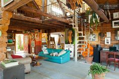 a living room filled with furniture and lots of wood planks on the walls,