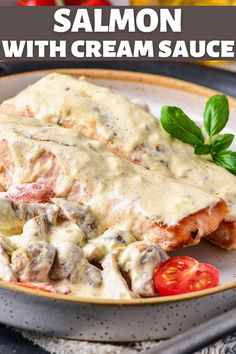 salmon with cream sauce on a plate with tomato and basil garnish in the background