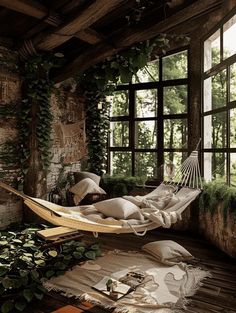 a hammock hanging from the ceiling next to a window with plants growing on it