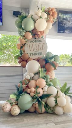 a tall tower made out of balloons and greenery