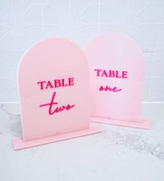 two pink table signs with the words table time on them sitting next to each other