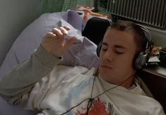 a man laying in bed with headphones on