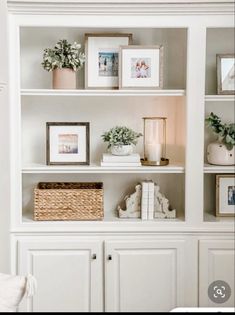 a white bookcase filled with books and pictures