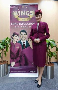 a woman standing in front of a sign with an advertisement for the airline on it