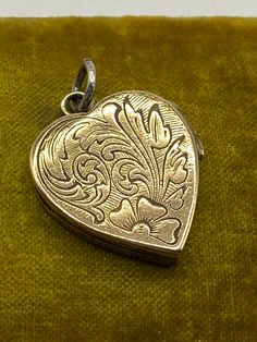 "Antique Victorian hand engraved Heart shaped Locket pendant, ca 1870 Hand engraved heart shaped locket with different floral designs on each side. One side has a shield cartouche that can be monogrammed if desired.  Locket opens and closes properly. The original frames and glassine coverings are secured within. Unmarked. Unsigned. Presumably gold filled.  Measures 1 1/8\" high with bail and 7/8\" wide. Light wear, fitting for age." Vintage Heart Charm Medallion Jewelry, Vintage Jewelry With Heart Charm Medallion, Ornate Heart-shaped Jewelry With Intricate Design, Engraved Jewelry Collectible For Valentine's Day, Victorian Heart Charm Locket Necklace, Hallmarked Heart-shaped Victorian Jewelry, Victorian Heart Charm Locket Pendant Necklace, Vintage Engraved Double Heart Necklace, Victorian Heart-shaped Hallmarked Jewelry