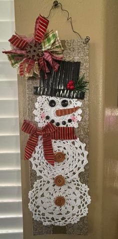 a crocheted snowman is hanging on the door