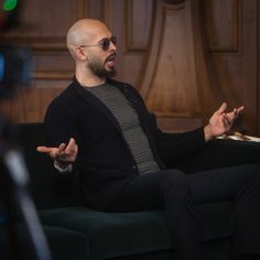 a bald man sitting on top of a green couch