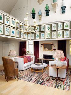 a living room filled with lots of furniture and pictures on the wall above it's fireplace