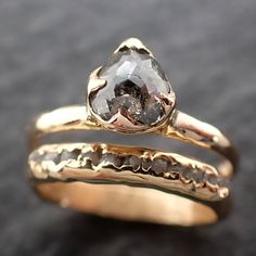 two gold wedding rings with a large diamond in the center, on top of each other