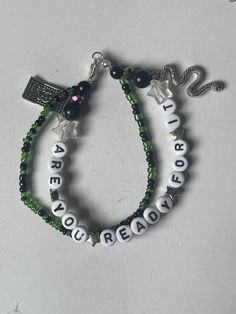 two bracelets with words and charms on them