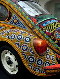 an intricately painted car is parked on the street