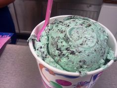 an ice cream sundae in a cup with a pink straw