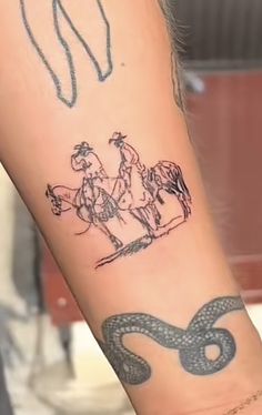 a tattoo on the arm of a person with a horse and rider drawn on it