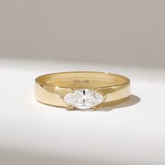 a close up of a ring with a diamond on the top and an engraving on the bottom