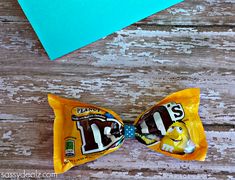 two candy candies sitting on top of a wooden table next to a piece of paper