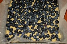 blueberries are spread out on top of the batter in a baking pan, ready to go into the oven