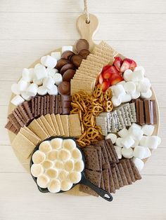 a platter filled with crackers, marshmallows, pretzels and strawberries