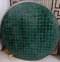 a green plate sitting on top of a tiled floor