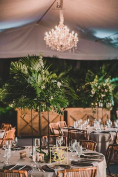 a table set up for an event with flowers and greenery