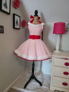 This Jovie the elf cosplay apron is great for a costume or for the perfect holiday hostess apron for entertaining. Full circle skirt, fully lined bodice, covered buckle, long waist sashes to fit most sizes. Faux fur trim on hem and neckline.  Material:  Body: 100% Cotton Faux Fur Trim: 100% Polyester Red Piping: Poly/Cotton Metal Self Covered Buckle Measurements: Across Bodice: 15" Skirt Length: 16" Neck Ties: 33" Waist Sashes: 39" Top of Bodice to Bottom of Skirt: 30" Fits Sizes S/M/L Best. Can Jovie The Elf, Cosplay Apron, Elf Apron, Murrells Inlet Sc, Elf Cosplay, Hostess Apron, Murrells Inlet, Waist Sash, Full Circle Skirt