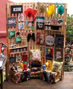 an outdoor store with lots of items on display in front of a pink wall and wooden slats