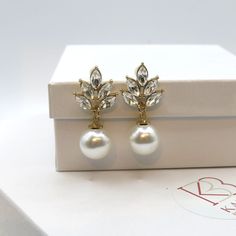 Bridal and bridesmaids large pearl and rhinestone fashion earrings. Wedding pearl drop crystal stud earrings.Sweet and tender, multiple leaf shaped rhinestones are clustered together with a larger round shaped pearl attached to it. The elegant studs add an extra feminine touch to your simple yet elegant look. Versatile and chic, the wedding style earrings will be a nice addition to a bridal outfit or suitable for any special occasion. DIMENSIONS: about 1.2"L x 0.8"WMATERIALS: Metal, faux pearls, Gold Pearl Earrings With Cubic Zirconia For Party, Gold Cubic Zirconia Pearl Earrings For Party, Gold Crystal Pearl Earrings For Wedding, Elegant Crystal Clip-on Earrings For Wedding, Glamorous Pearl Earrings As Gift, Glamorous Pearl Embellished Earrings As Gift, Glamorous Pearl Embellished Earrings For Gift, Gold Elegant Crystal Earrings For Bridesmaid, Party Crystal Earrings With Pearl Drop And Cubic Zirconia