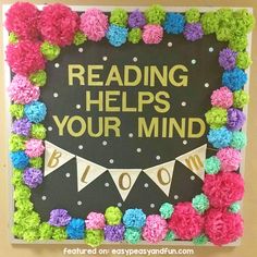 a bulletin board that says reading helps your mind blow out with pom poms