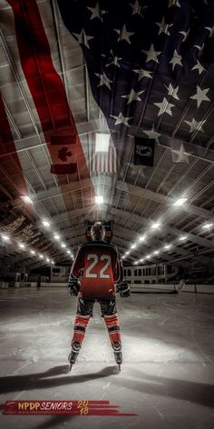 an ice hockey goalie standing in front of the american flag with his hands on his hips