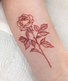 a small rose tattoo on the arm