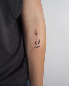 a woman's arm with a small flower tattoo on the left side of her arm