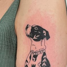 a black and white dog tattoo on the right arm, with arrows in its collar