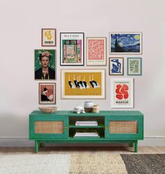 a living room with pictures on the wall and a coffee table in front of it